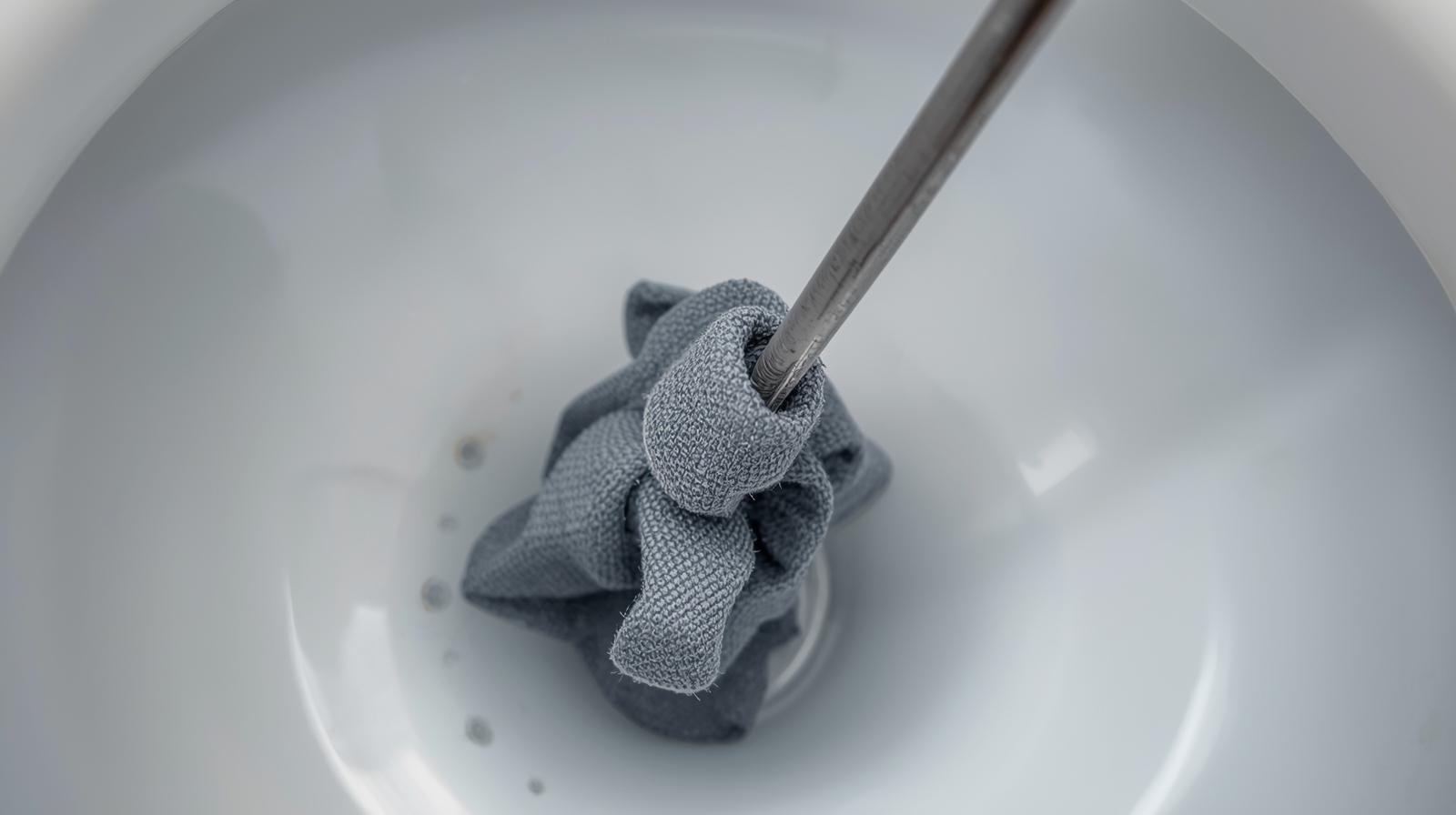 Một chiếc móc quần áo bằng kẽm đã được duỗi thẳng, đầu móc được quấn giẻ cẩn thận